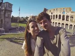 Tourist couple taking a selfie in front of the Coliseum Stock Footage
