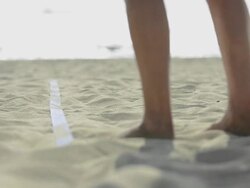 ECU of female beach volleyball players feet and legs as she serves. Stock Footage