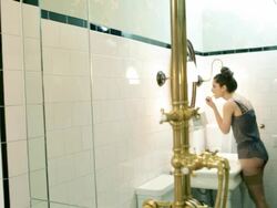 Young woman applying lipstick in bathroom mirror Stock Footage