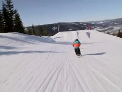 A skier doing a jumping trick on skis in the winter at a ski resort. Stock Footage
