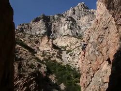Handheld shot of rock-climber navigating a vertical formation. Stock Footage