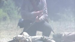 Confederate soldiers fire rifles near a dead soldier in a Civil War reenactment. Stock Footage