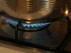 Backzoom from a gas stove blue flame Stock Footage