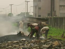 WS View of burning plastic with people / Lagos, Nigeria Stock Footage