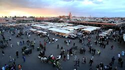 Shoppers walk around lighted stalls in the Djemaa el-Fna souk in Marrakesh. Stock Footage
