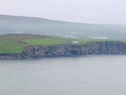 MS AERIAL Shot of city on mountain and lighthouse on island cliff / Iceland Stock Footage