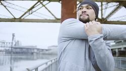 Attractive ethnic male exercising/stretching outdoors Stock Footage