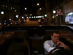 MS POV Well dressed young man driving in modern convertible car in aurban area at night / Minneapolis, Minnesota, United States Stock Footage