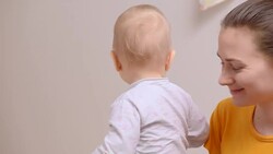 feeding baby while he watching animated cartoon Stock Footage