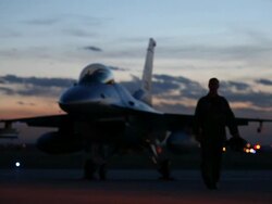MS F-16 pilot walking away from F-16 fighter jet into light at dusk, Aurora, Colorado, USA Stock Footage