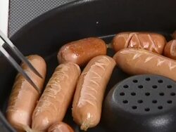 Frankfurter sausage being backed in pan Stock Footage