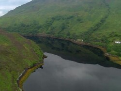 Aerial over Loch Long in Scottish Highlands with reflection of valley in still water / Scotland Stock Footage