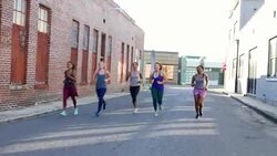MS Group of women running together on urban street at sunrise Stock Footage