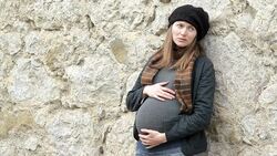 Pregnant woman standing near the city wall Stock Footage