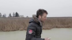 Young man selecting music while ice skating on frozen pond in winter in rural Montana, USA. Stock Footage