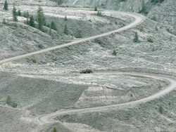 WS View of logging truck traveling through grasslands / Williams Lake, British Columbia, Canada Stock Footage