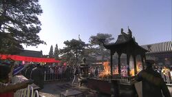 Police control worshipers and spectators as a fire burns in the courtyard of the Bai Yun Guan Temple in Beijing. Stock Footage