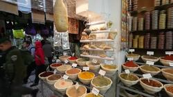 Shoppers pass by a market stall displaying spices. Stock Footage