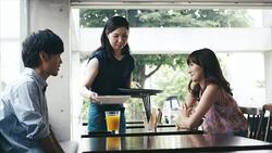 Waitress serves asian couple in cafe Stock Footage