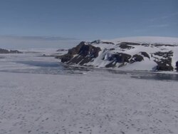 LOW AERIAL, Frozen sea and rock formations, Cape Mill, Franz Josef Land, Russia Stock Footage