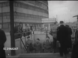 1953: POTSDAMER PLATZ: BERLIN, GERMANY: LA WS Free Berlin Press electric news ticker scrolling news in German, TD to people walking around Potsdam Square. VS East German refugees at newspaper stand, reading 'Der tages Spiegel.' Instructional Video