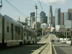 Slow panning shot of train driving down the street in Los Angeles. Stock Footage