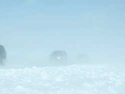 Winter Blizzard with Blowing Snow Across Highway and Vehicles Stock Footage