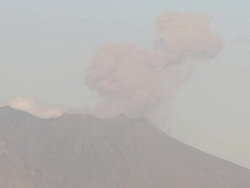 Ash erupts from Sakurajima volcano as ship docks in Kagoshima port, Japan Stock Footage