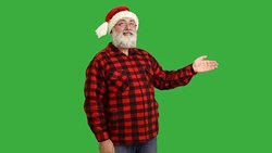 adult senior beard man showing an copy space and  crosses his arms in a hat santa claus  on a green background Stock Footage