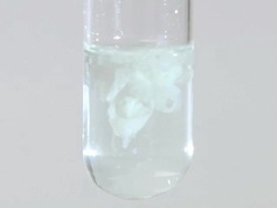 Iron (ii) hydroxide precipitate, formed as sodium hydroxide is dripped into iron (ii) chloride solution Stock Footage