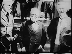 B/W 1900s Andrew Carnegie standing between two senior men with eyeglasses / newsreel Stock Footage
