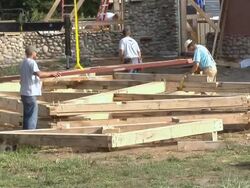 MS Carpenters preparing to move rafters while framing an energy efficient post / Grass Lake, Michigan, USA      Stock Footage