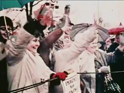 1962 crowd of people with umbrellas waving excitedly outdoors at parade for John Glenn Stock Footage