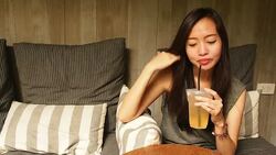 Asian woman drinking fresh peach soda Stock Footage