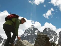 Hiker traverses rock ridge b/t pinnacles, mtns behind Stock Footage