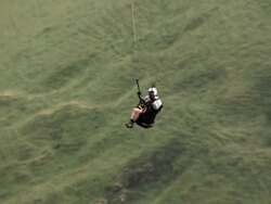 MS TS SLO MO Shot of paraglider flying above hill tops Stock Footage