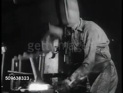 1941: AUSTRALIA MUNITIONS: Men walking steps outside commonmwealth Government Small Arms Factory. INT Factory:  Male holding, turning hot metal as machine hammers. INT Foundry. Young adult male polishing gun stock. Man inspecting rifles. WWII Instructional Video
