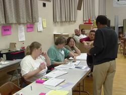 MS, ZI, Man checking in and talking to women sitting behind table at polling place, Toledo, Ohio, USA Stock Footage