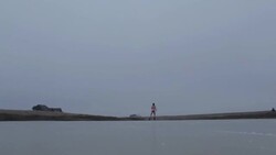 Young man ice skating in pink underwear on frozen pond in winter in rural Montana, USA. Stock Footage