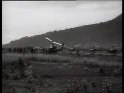 B/W 1960's wide shot of parked helicopters in field / Vietnam / SOUND Stock Footage