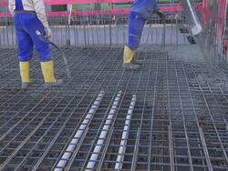Workers Directing Concrete Onto The Construction Site Stock Footage