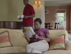 MS PAN Woman sitting in living room man joins her with beverage mugs / Portland, Oregon, United States  Stock Footage