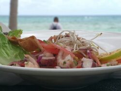 CU Shot pf  shrimp and octopus salad with the sea in the background / Playa del Carmen, Quintana Roo, Mexico Stock Footage
