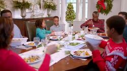 Family pass plates around table for Christmas dinner, young boy makes face as grandpa serves him vegetables (dolly-shot) Stock Footage