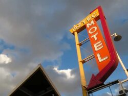 Time lapse of Route RT66 motel sign from demolished motel in the 1950's with beautiful golden clouds quickly passing at magic hour Stock Footage