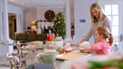 Mother and daughter roll out and flatten cookie dough in kitchen (dolly-shot) Stock Footage