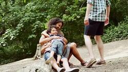 Family bonding on log in woods Stock Footage
