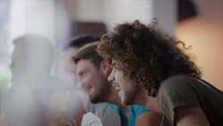 Guys sitting on couch watching funny movie Stock Footage