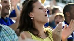 Spectators cheer and applaud at a football game. Stock Footage