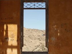 MS PAN View from inside yellow walled house of partially destroyed window with trucks and cars moving/ Road from Tocopilla to Gatico, Atacama desert, Chile Stock Footage